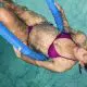 pregnant woman with foam roller in the pool
