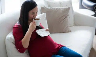 pregnant woman having coffee in living room
