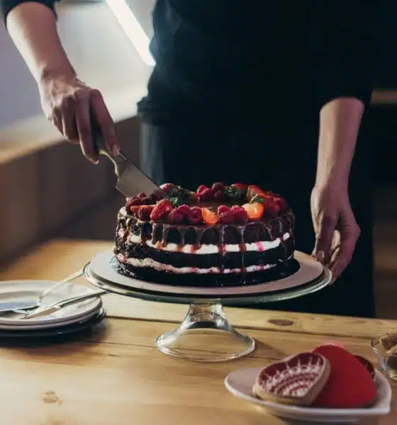 rich chocolate cake with strawberries being cut 2026 03 12 23 56 11 utc