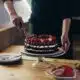 rich chocolate cake with strawberries being cut 2026 03 12 23 56 11 utc