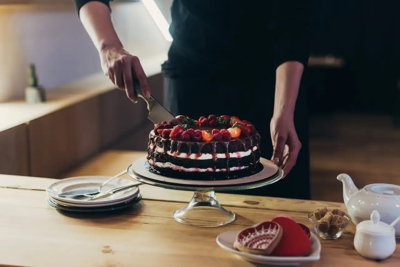 rich chocolate cake with strawberries being cut 2026 03 12 23 56 11 utc