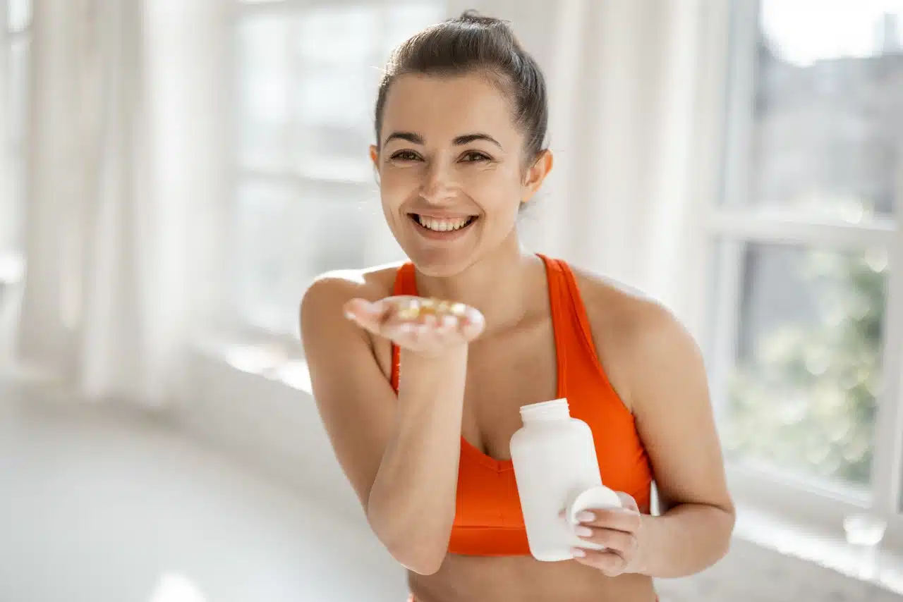 sports woman takes supplements or vitamins at gym 2026 03 25 00 19 09 utc